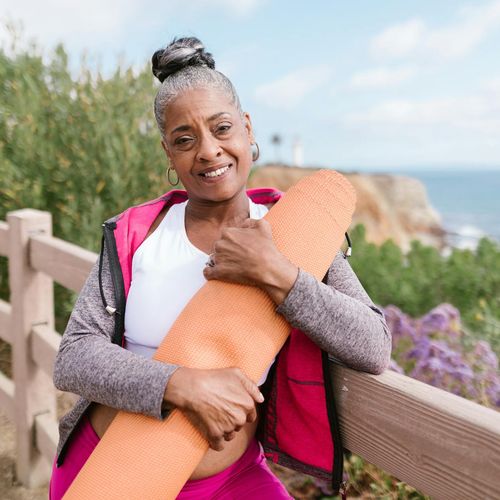 Person smiling peacefully outdoors, representing a state of general well-being.